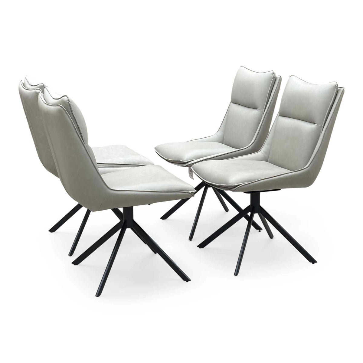 Four taupe faux leather swivel dining chairs from the Catalina set, angled from the left
