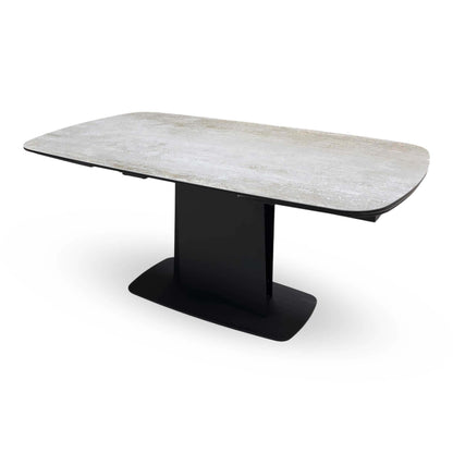 Catalina ceramic top dining table closed, angled view of the grey stone-effect top and black pedestal