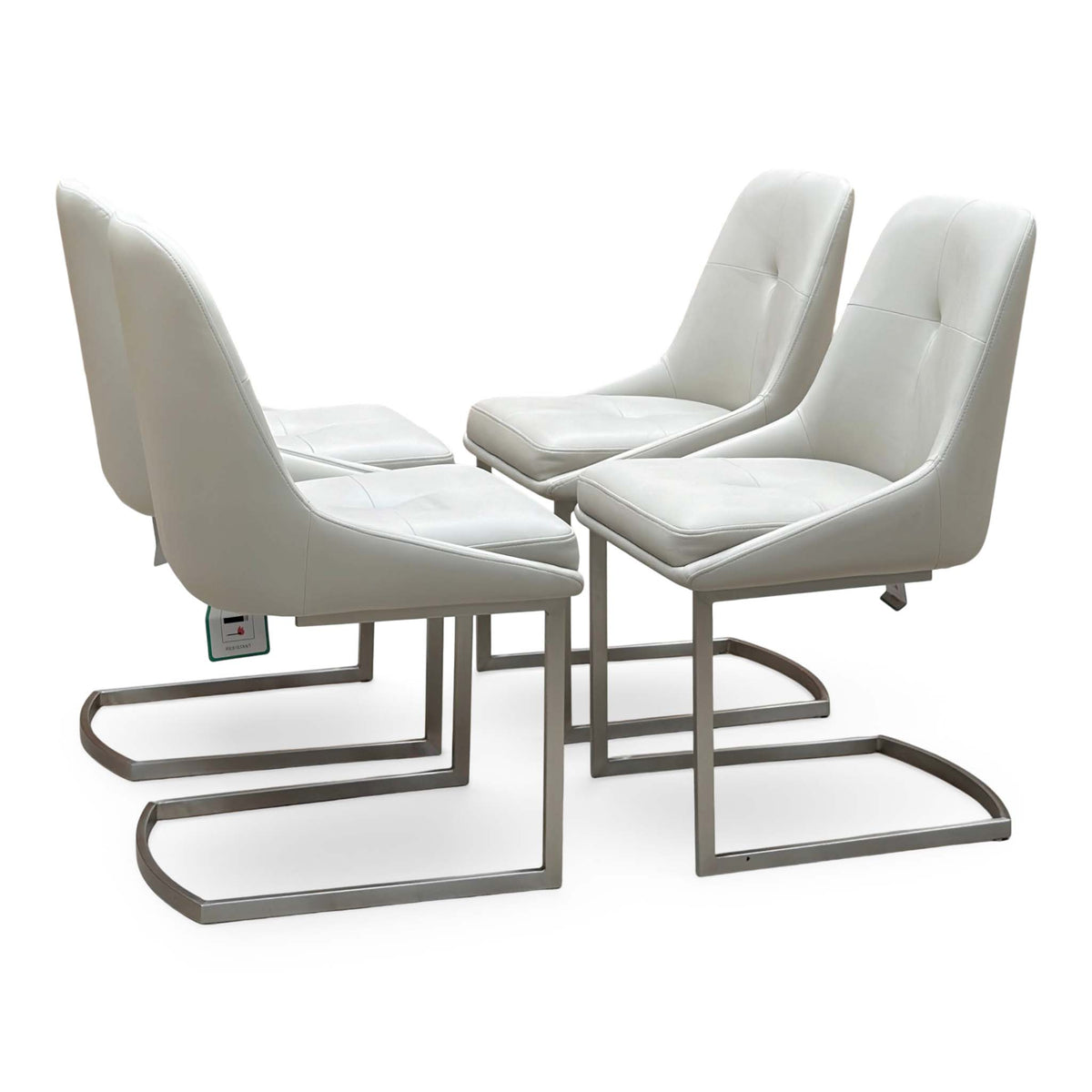 Avorio neutral faux leather set of 4 cantilever dining chairs, angled view showing the button backs and metal frames