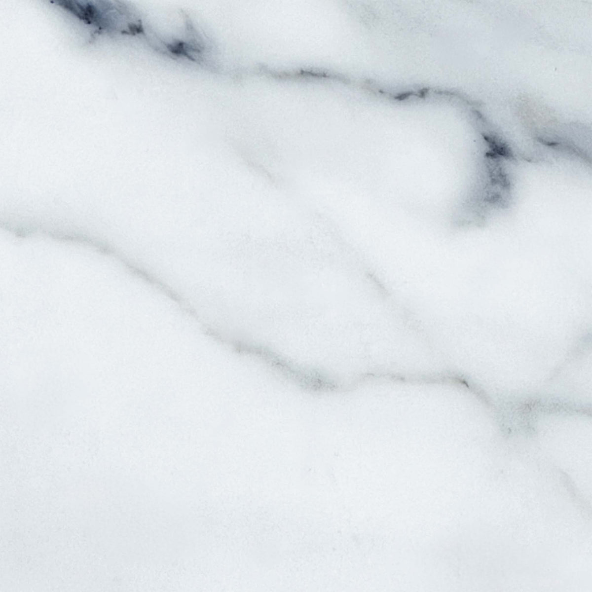 Close-up of the white and grey veined marble effect ceramic top used on the Jose dining table