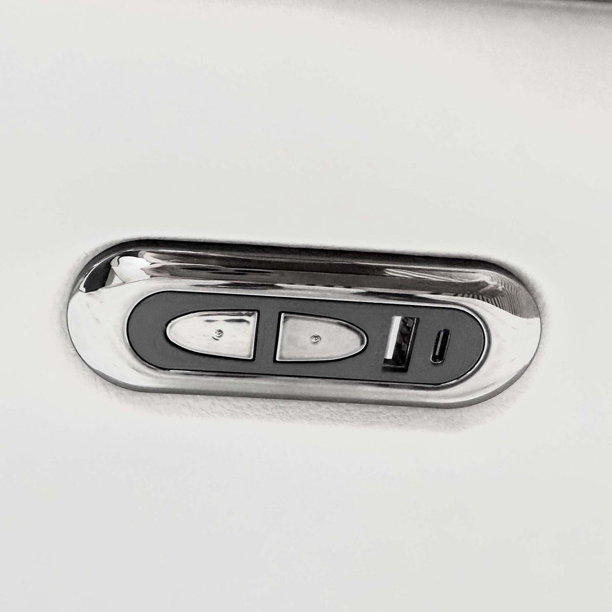 Close-up of the chrome power recline control with USB ports on the arm of the Sally light grey leather sofa