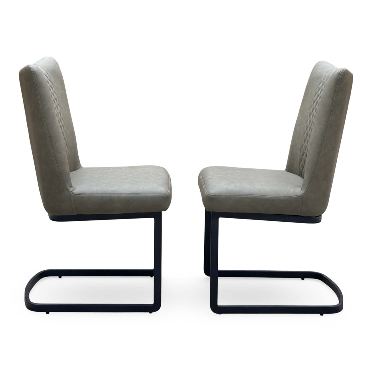 Side view of the Bodahl Loki olive green fabric pair of cantilever dining chairs facing each other on black frames