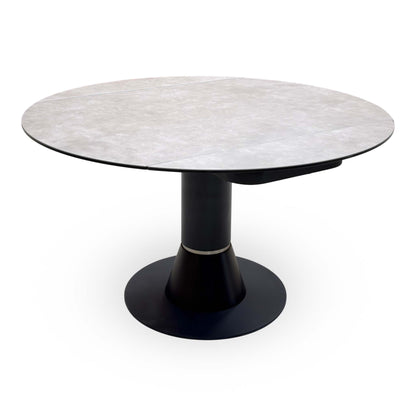 Enterprise grey ceramic top round dining table fully opened, angled from the right showing the join underneath