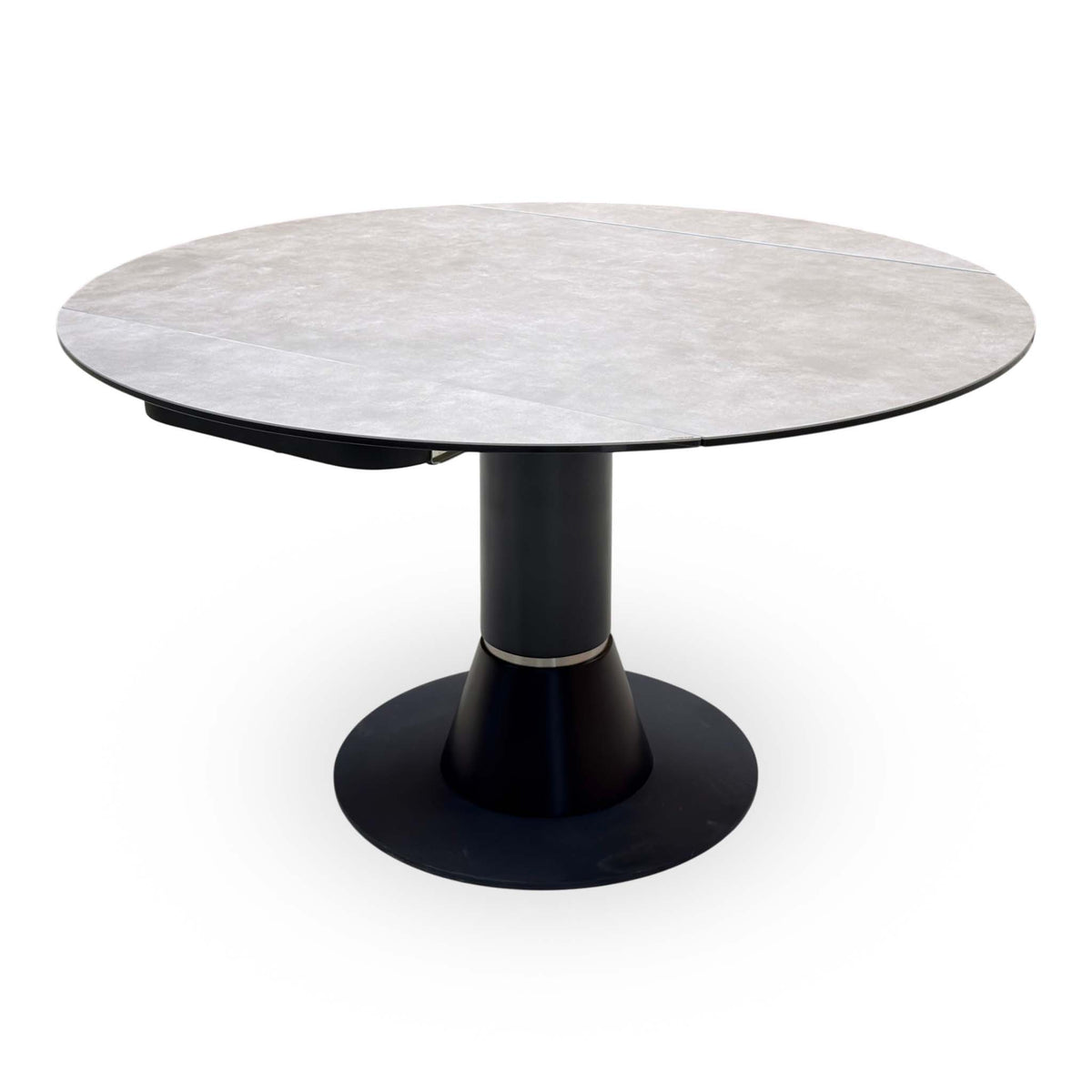 Enterprise grey ceramic top dining table swivelled open to a full round, angled view