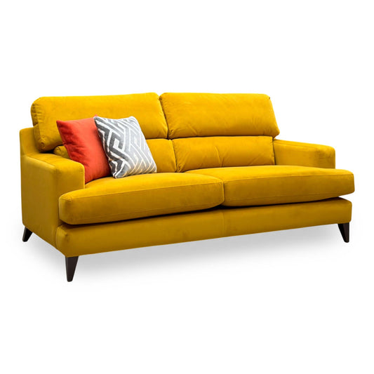 The Lounge Co. Romilly golden spice yellow velvet 3 seater sofa, angled view with scatter cushions