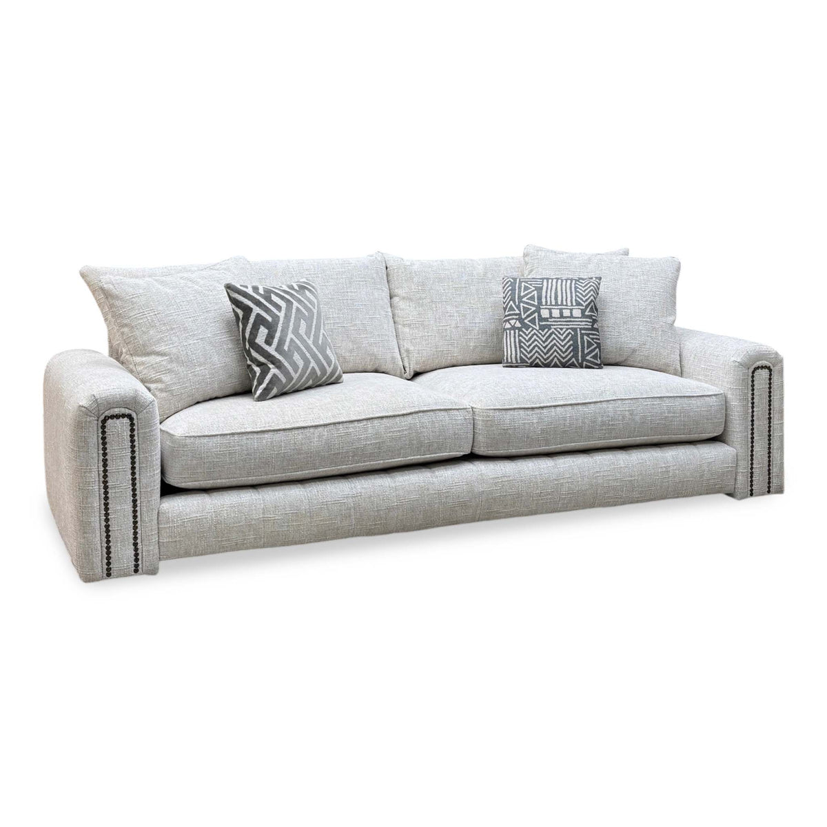 Retreat white woven fabric 4 seater sofa with studded arms and two patterned cushions, angled view
