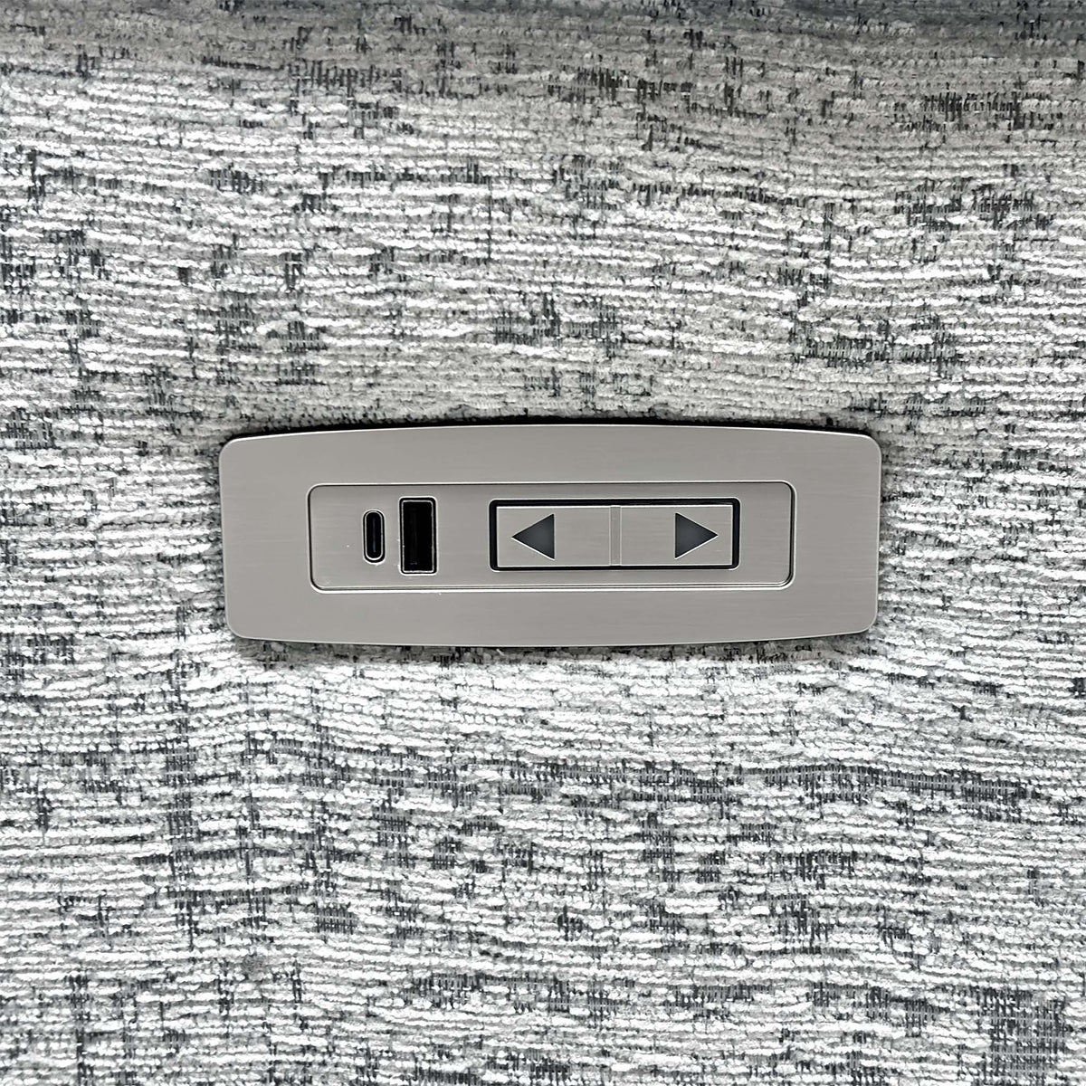 Close-up of a single power recline switch and USB-C port set into the G Plan Kingsbury mist grey fabric