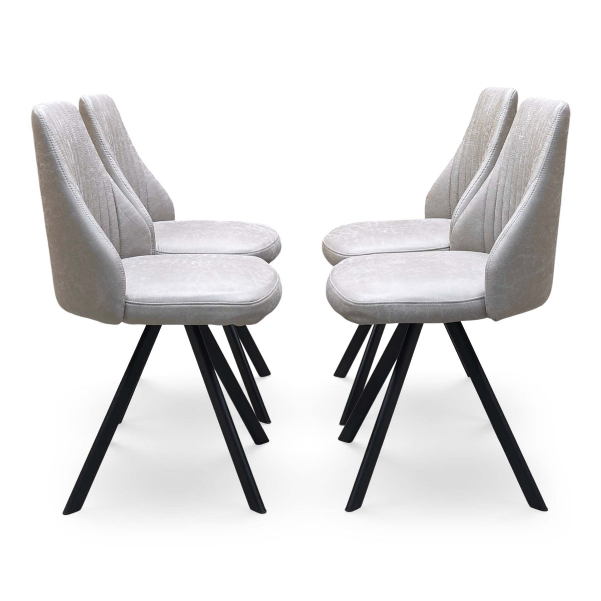 Side profile of the Vida taupe faux leather swivel dining chairs on angled black metal legs