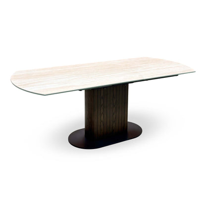 Tiber travertine ceramic extending table on its own, extended on a dark wood pedestal base, angled view