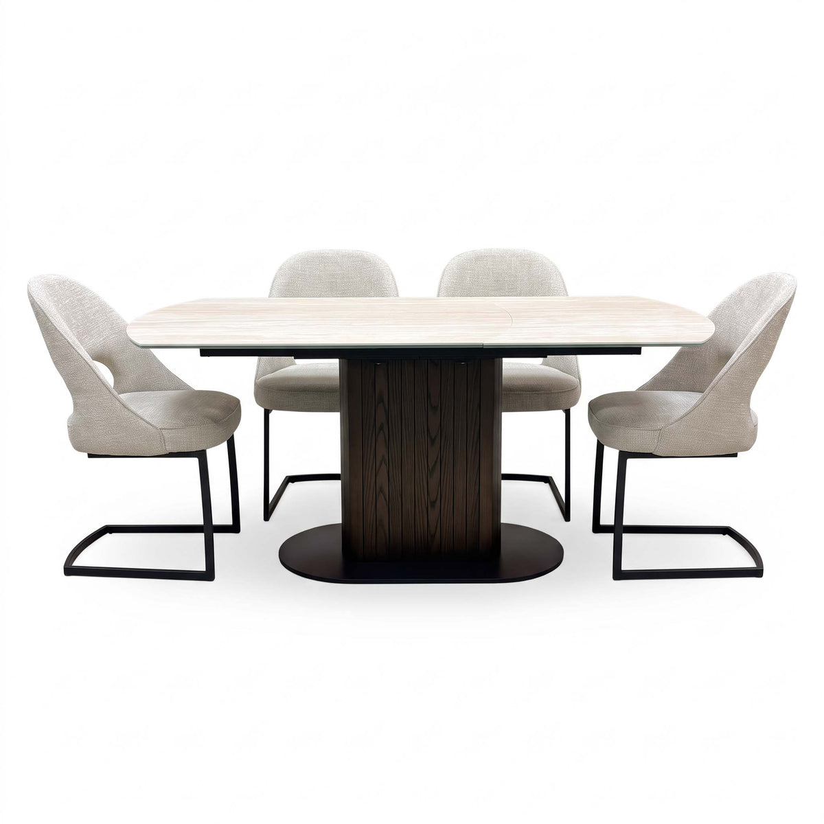 Front view of the Tiber travertine ceramic extending table with four beige cantilever chairs spaced along both sides