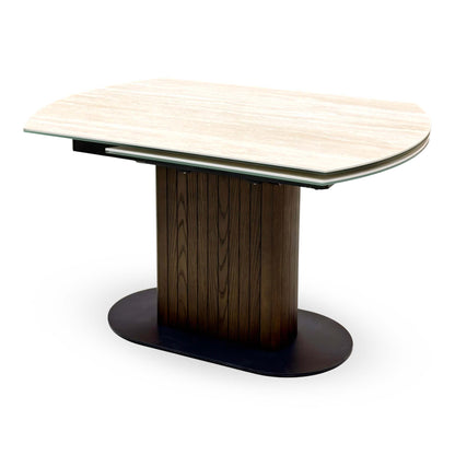 Tiber travertine ceramic table on its own in the closed position, angled view of the oval dark wood pedestal