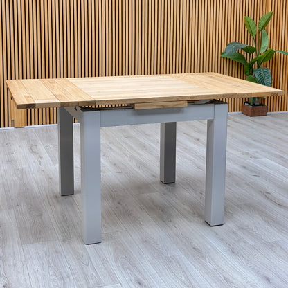 Lewis solid oak small draw leaf extending dining table, fully extended with grey painted legs in the showroom