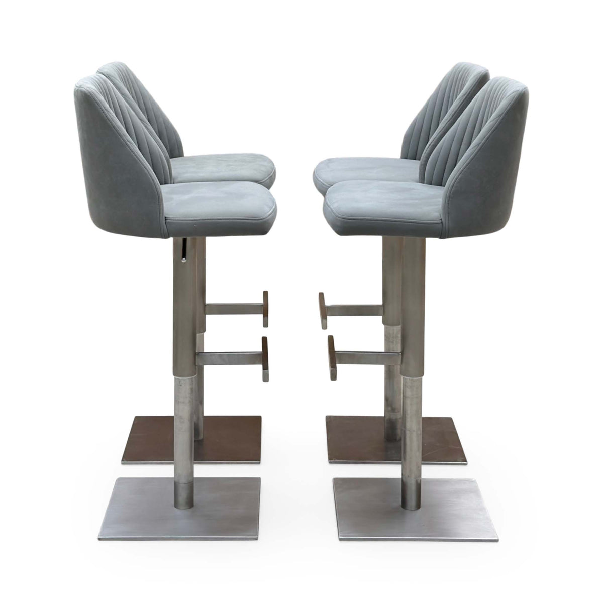 Side angle of the Grigio grey fabric bar stools showing the curved backs and footrests on steel columns