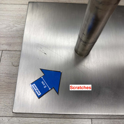 Scratches on the steel base plate of a Grigio bar stool beside the column, marked with a 5cm arrow