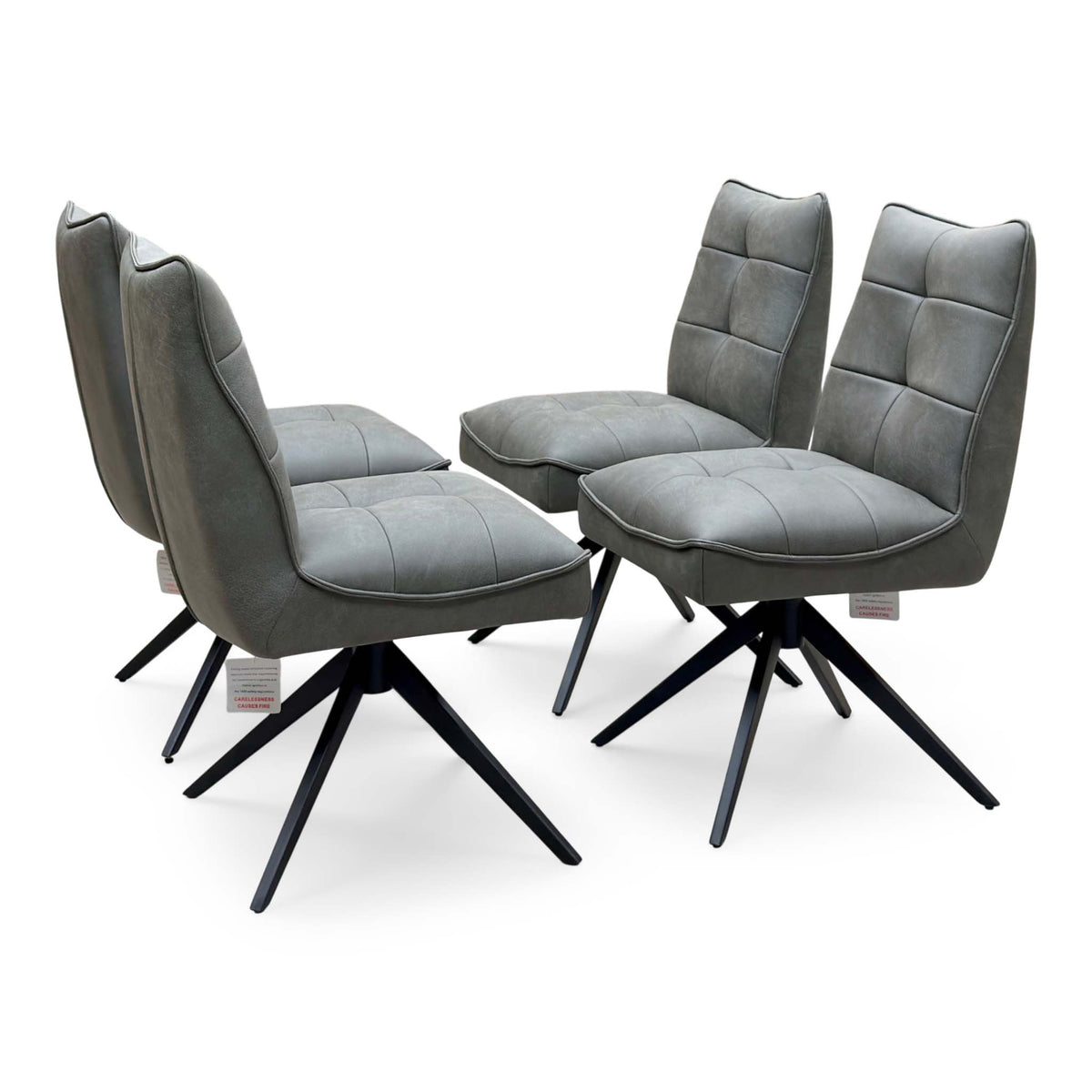 Germain charcoal grey faux leather set of 4 swivel dining chairs, angled view with quilted stitched seats
