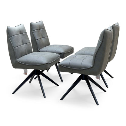 Germain charcoal grey faux leather set of 4 swivel dining chairs, angled from the right on a plain background