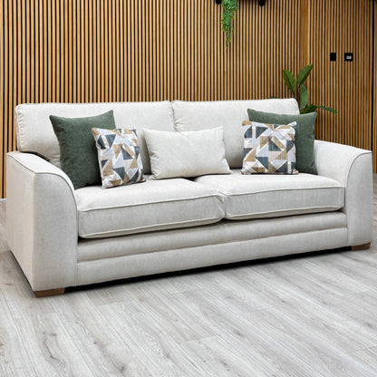 Kaluna natural fabric 3 seater sofa with scatter cushions, photographed against a slatted wooden wall