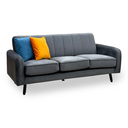 Jennifer dark grey velvet 3 seater sofa with fluted back, angled view with blue and orange scatter cushions