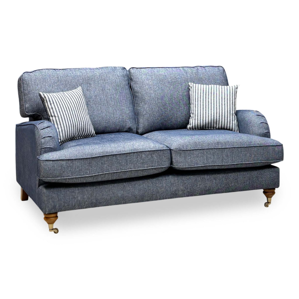 Bay navy blue plain fabric 2 seater sofa, angled view with striped scatter cushions and turned legs on castors