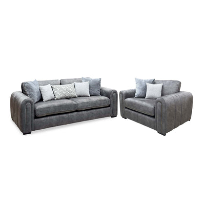 Amara charcoal grey velvet 3 seater sofa and snuggle chair with scatter cushions, angled view with the sofa on the left