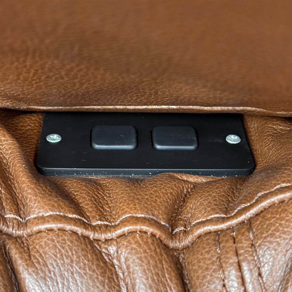 Close-up of the two-button power recline control on the side of the Marinelli Viali bark brown leather chair