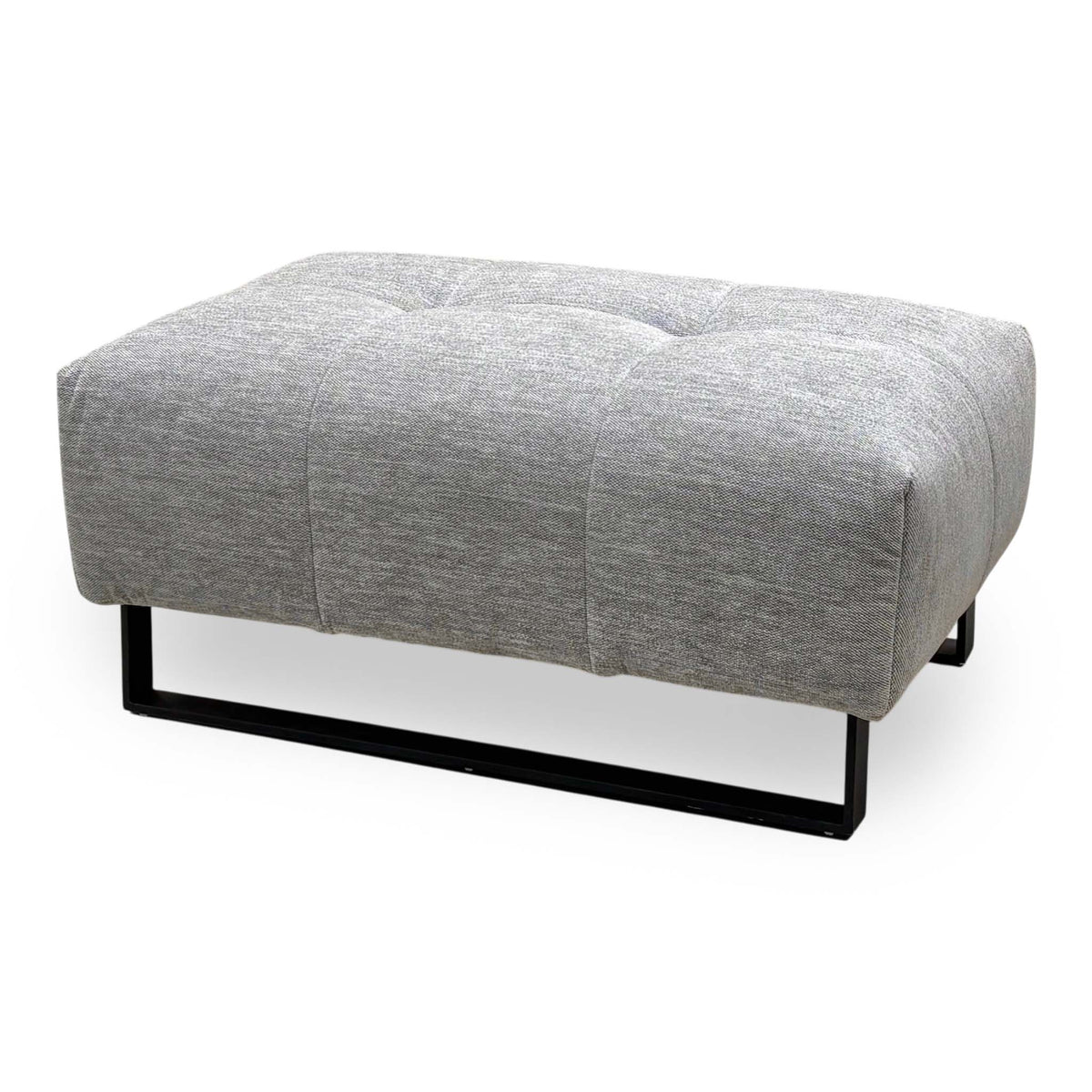 Shelby dove grey fabric footstool with tufted top on a black metal sled base, angled cut-out