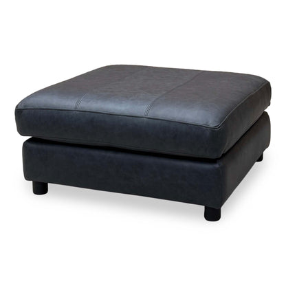 Side angle of the Romilly navy blue leather footstool showing the padded top and short block feet