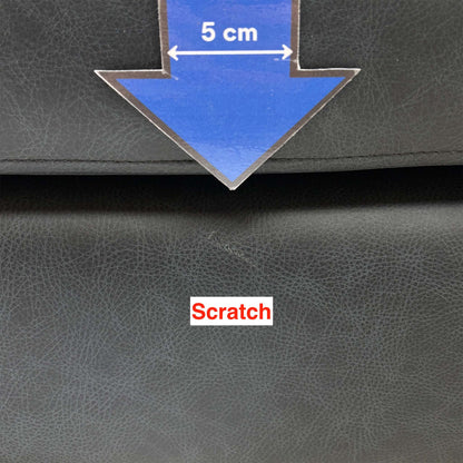 Close-up of a faint scratch below the top seam of the Romilly navy leather footstool, 5cm arrow for scale