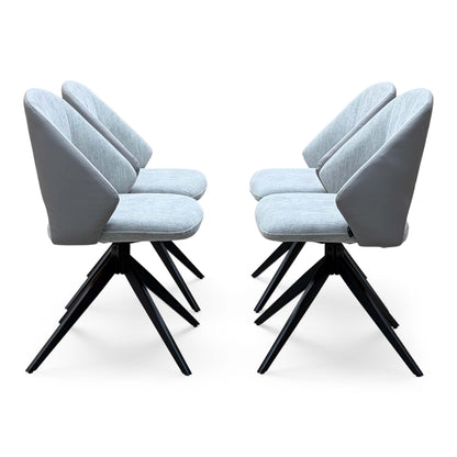 Side angle of the Raul stone grey fabric swivel dining chairs showing the curved backs and spider legs