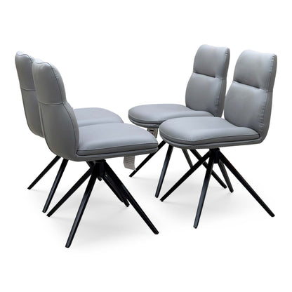 Quattro stone grey faux leather set of 4 swivel dining chairs, angled view with black splayed metal legs