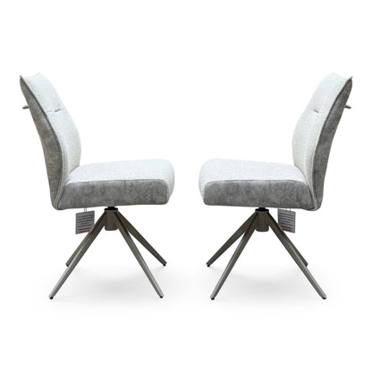 Side angle of the Mirage neutral fabric swivel dining chair pair showing the brushed metal star bases