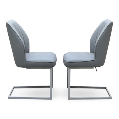 Side profile of the Fumo grey faux leather cantilever dining chairs facing each other showing the chrome frames