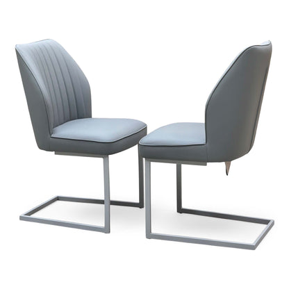 Angled view of the Fumo grey faux leather pair of cantilever dining chairs both facing forward