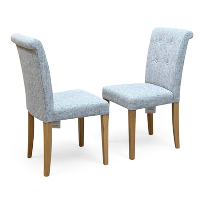Furnitureland Augusta mist grey fabric pair of roll back dining chairs on oak legs, angled view