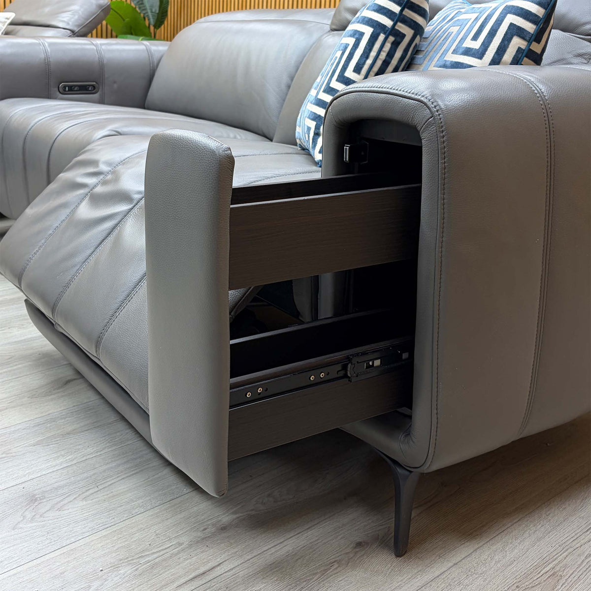 Close-up of the open storage arm on the Elphaba elephant grey leather sofa showing the pull-out drawer runner