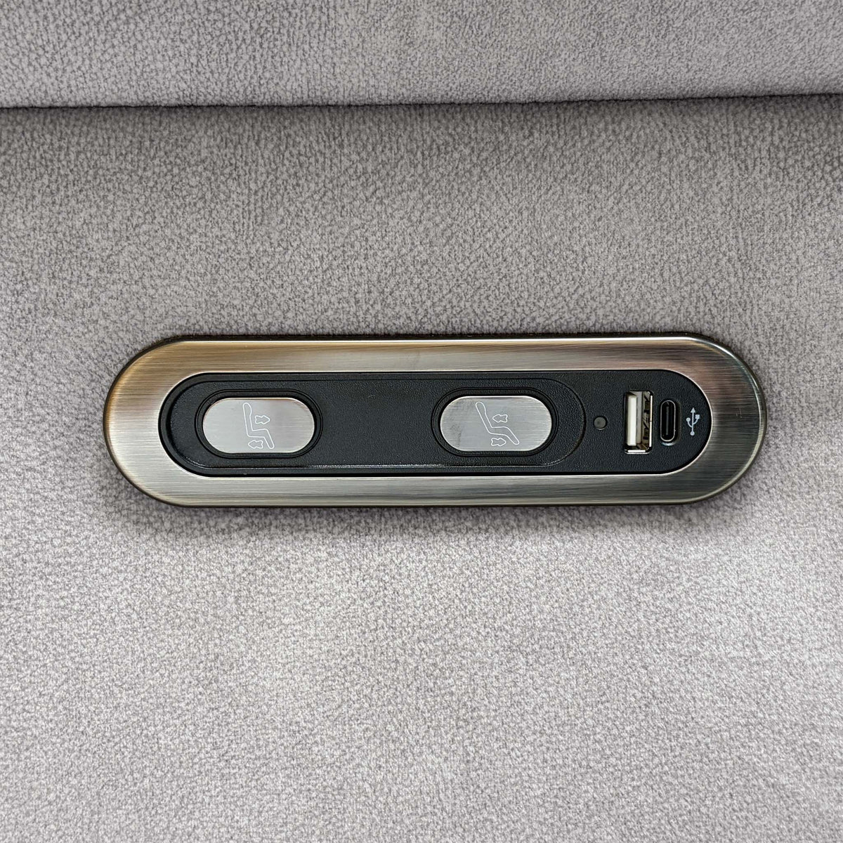 Close-up of the Raven stone grey power recline buttons with USB-A and USB-C charging ports