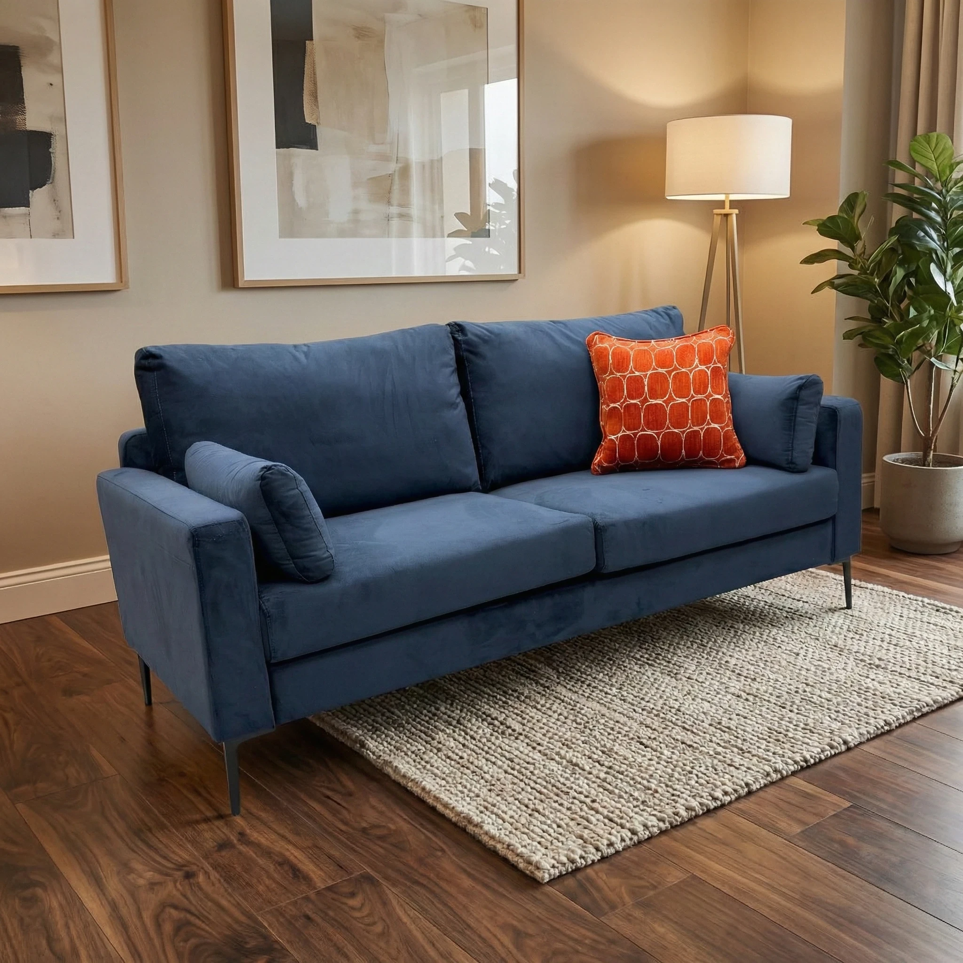 Lifestyle studio shot of the ‘Wren’ Navy Blue sofa, highlighting its luxurious velvet upholstery and contemporary silhouette.