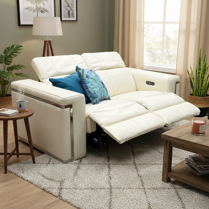 Lifestyle view of the 'Cora' 2-seater sofa in a bright living room environment, showcasing its elegant profile and sophisticated chrome accents.