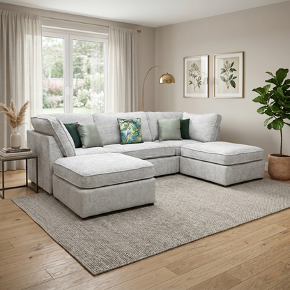 Living room view Feature graphic for the Emilia Silver U-shape sofa, showcasing its contemporary low-back silhouette and the generous array of coordinated scatter back cushions.