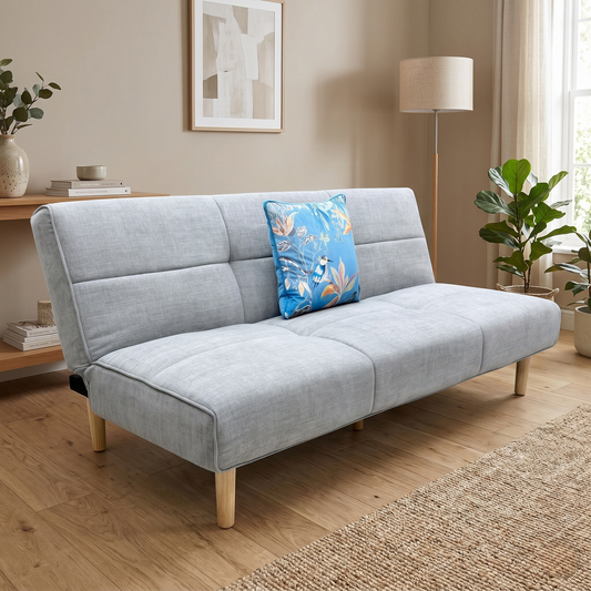 Living room view for the ‘Miyagi’ mist grey fabric futon sofa bed, highlighting its space-saving fold-down mechanism, medium comfort seating, and contemporary click-clack design.
