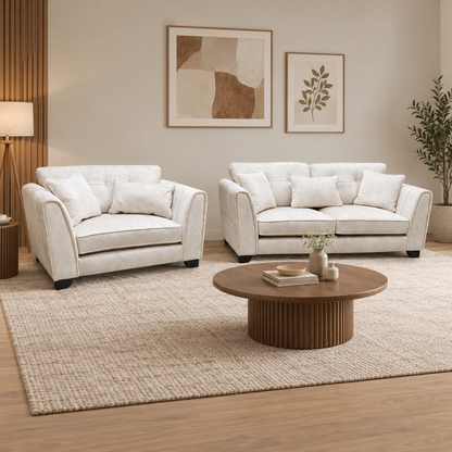 Mariah Dapple ivory fabric 3 seater sofa and snuggler chair in a living room with a round fluted coffee table