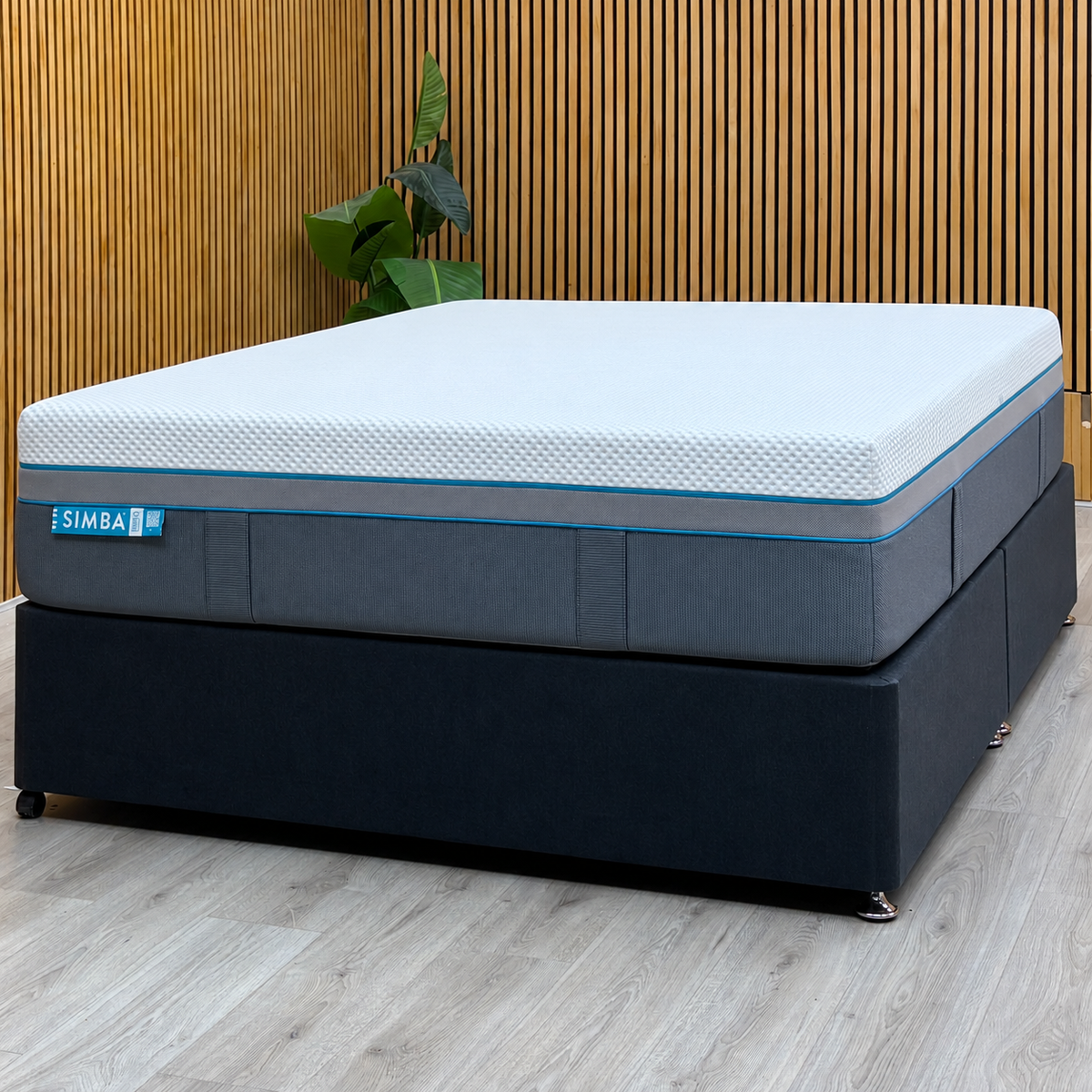 Simba Ultra Hybrid 7300 king mattress on a dark grey divan base against a slatted wood wall