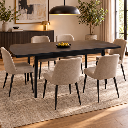 Magda black oak extending dining table in a dining room with six beige fabric chairs and a bowl of pears