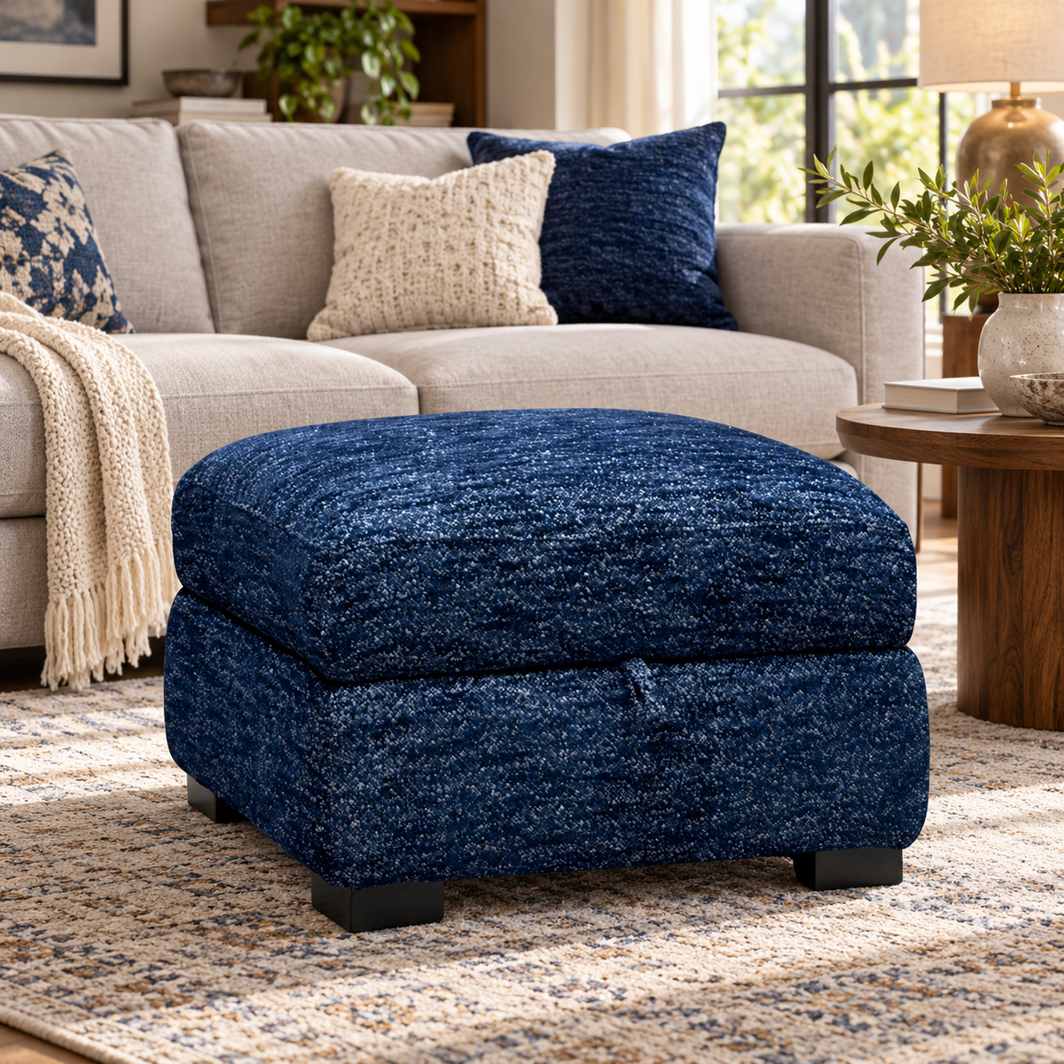 Nova dark denim blue storage footstool in a living room in front of a cream sofa on a patterned rug