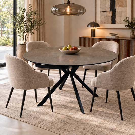 Quattro dark grey ceramic round dining table in a dining room with four beige upholstered chairs