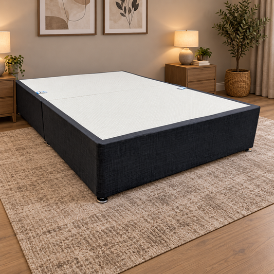 Reggie dark grey fabric double divan base in a bedroom on a brown patterned rug