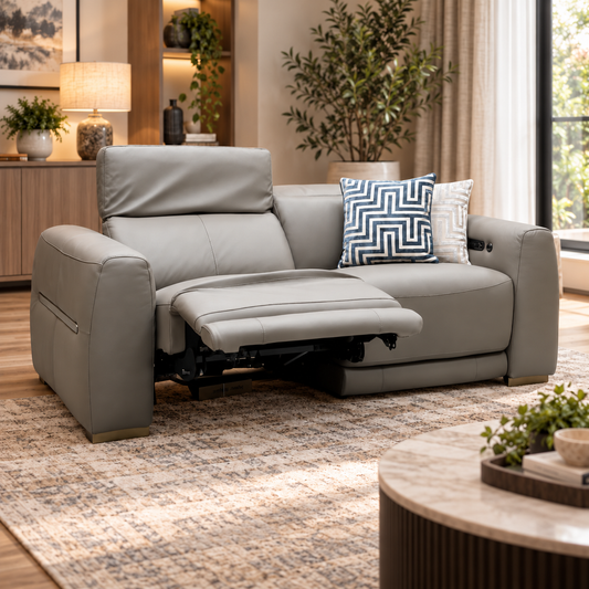 Edison taupe leather 3 seater power recliner sofa reclined in a living room with a patterned rug and side lamp