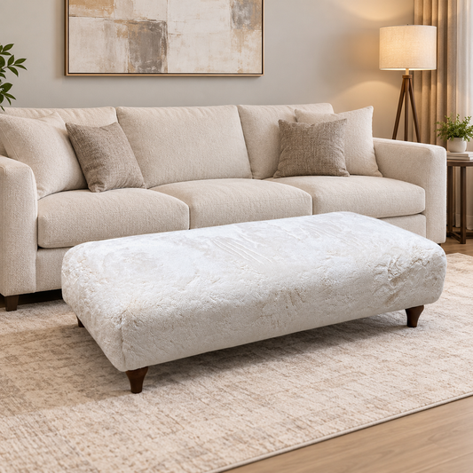 Ideal Home Cotswold ivory white faux fur bench footstool in a living room in front of a cream 3 seater sofa