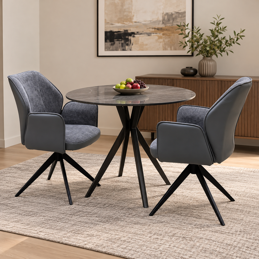 Julio anthracite grey swivel dining chairs either side of a round dark table in a dining room scene