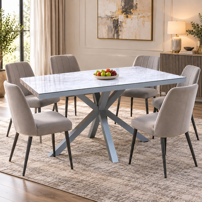 Fumo grey dining table in a dining room with six grey velvet chairs and a bowl of fruit on the marble-effect top